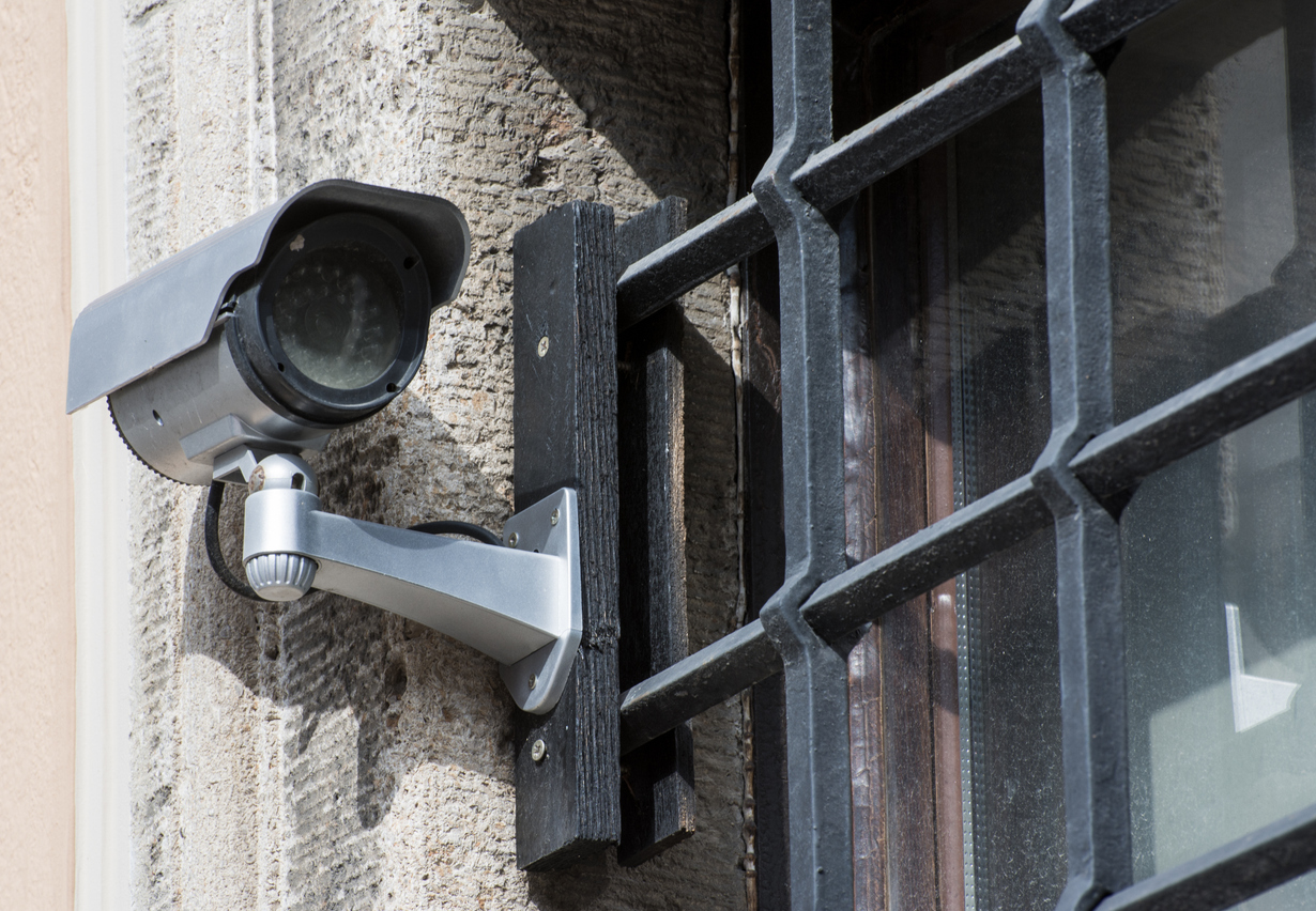 A surveillance camera mounted outside prison bars