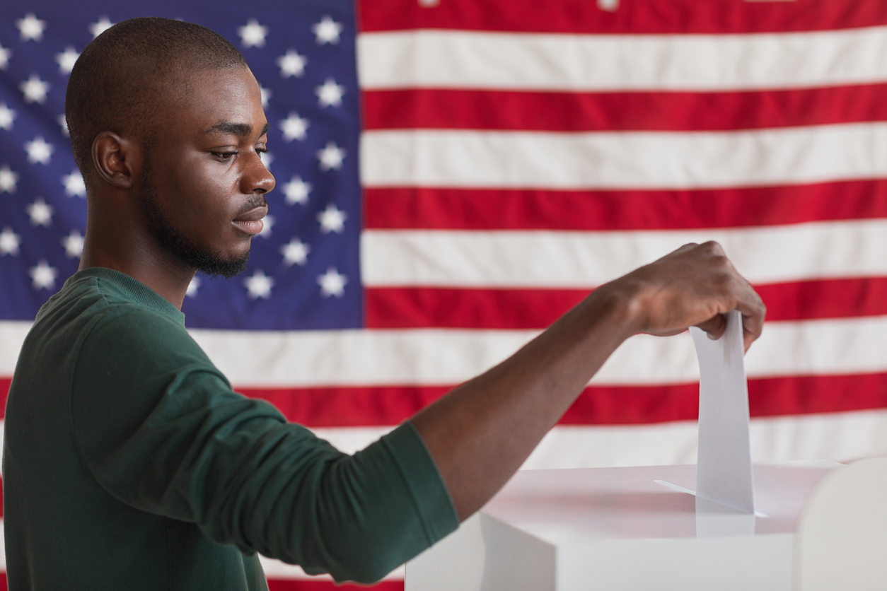 Black man voting in front of an American flag