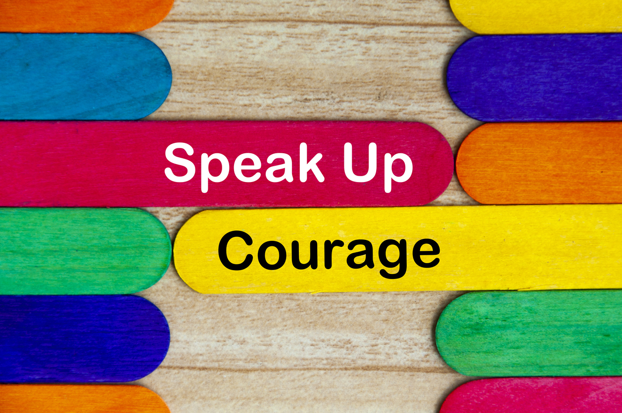Speak up and courage text on colored wooden stick