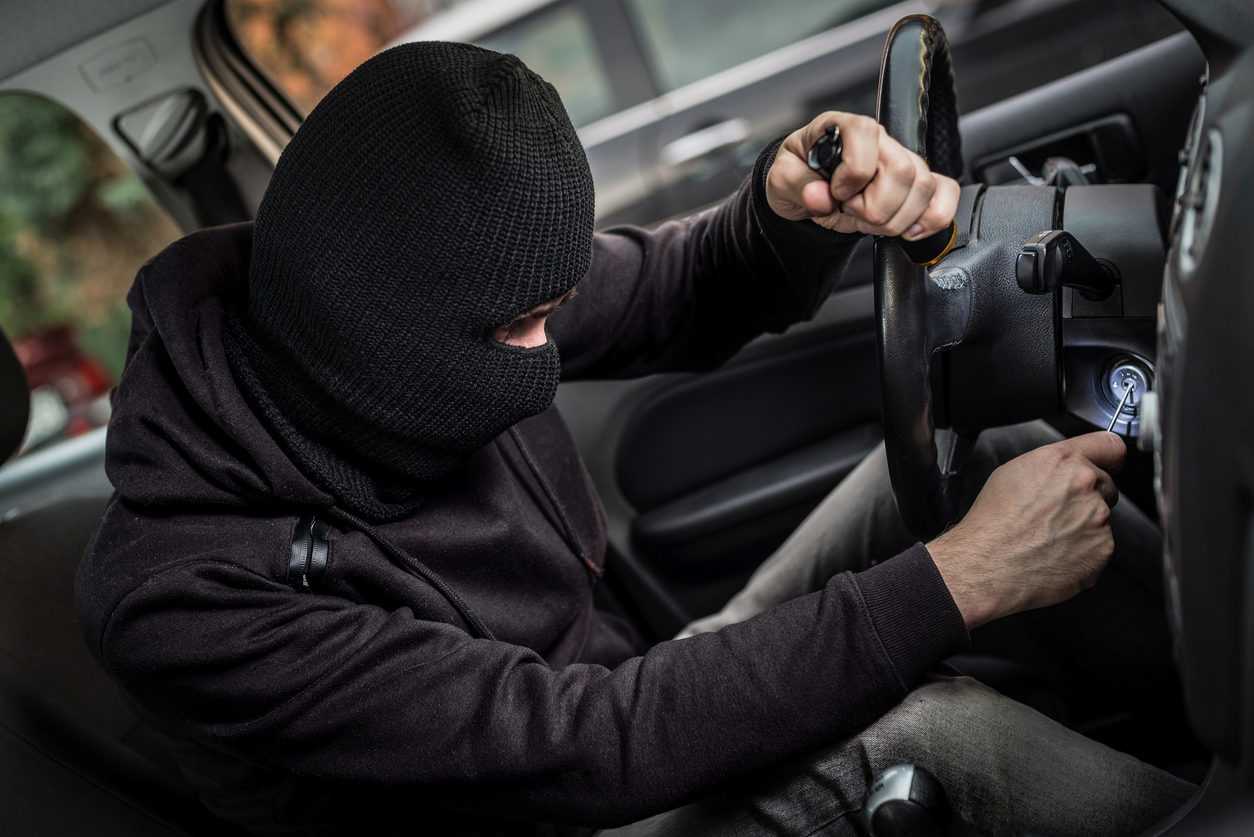 Car thief tries to start the car with a screwdriver in the ignition. Car thief, car theft