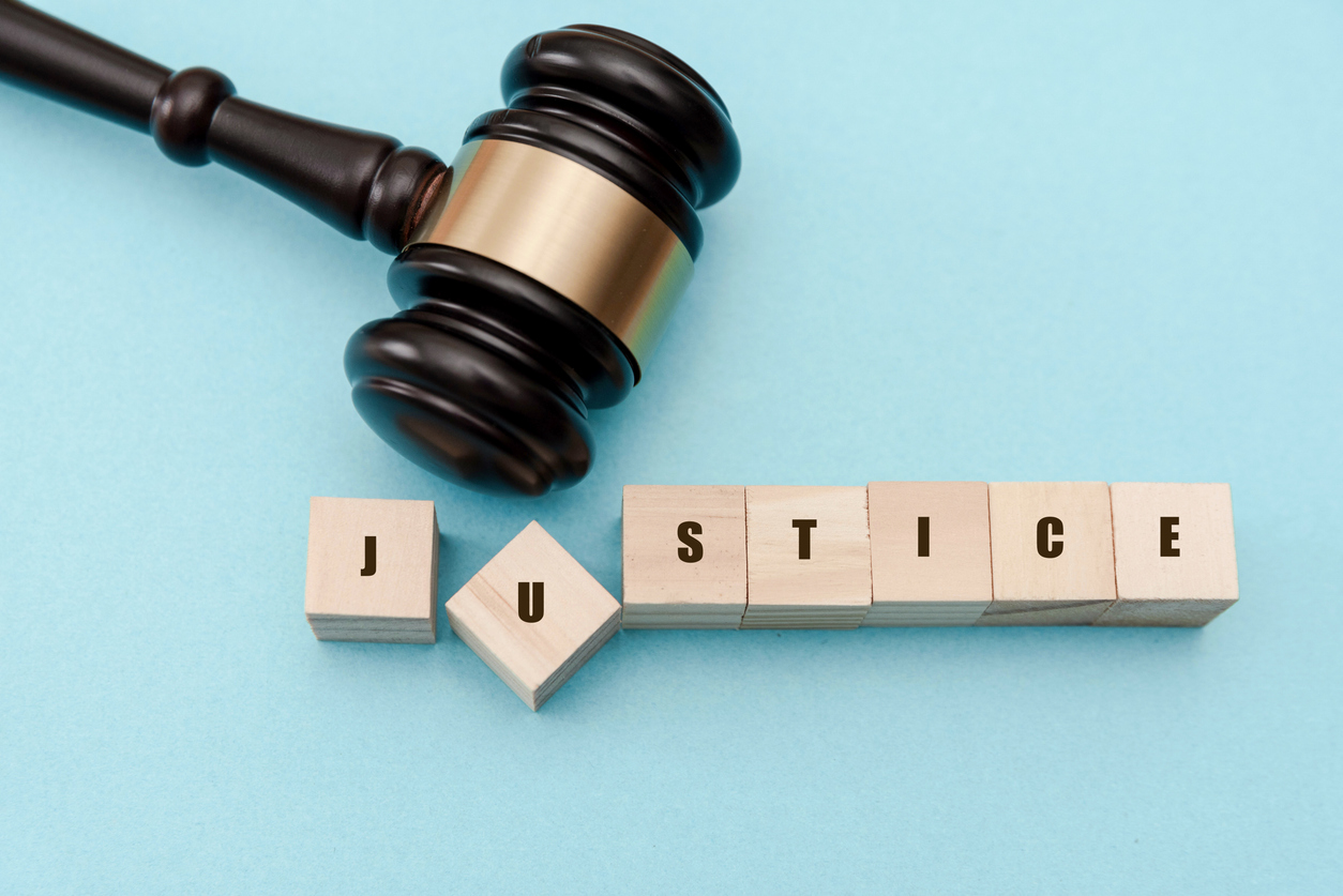 Judge's gavel knocking the "u" in justice out of place