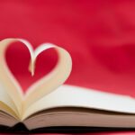 Opened book with heart shape made by the pages.