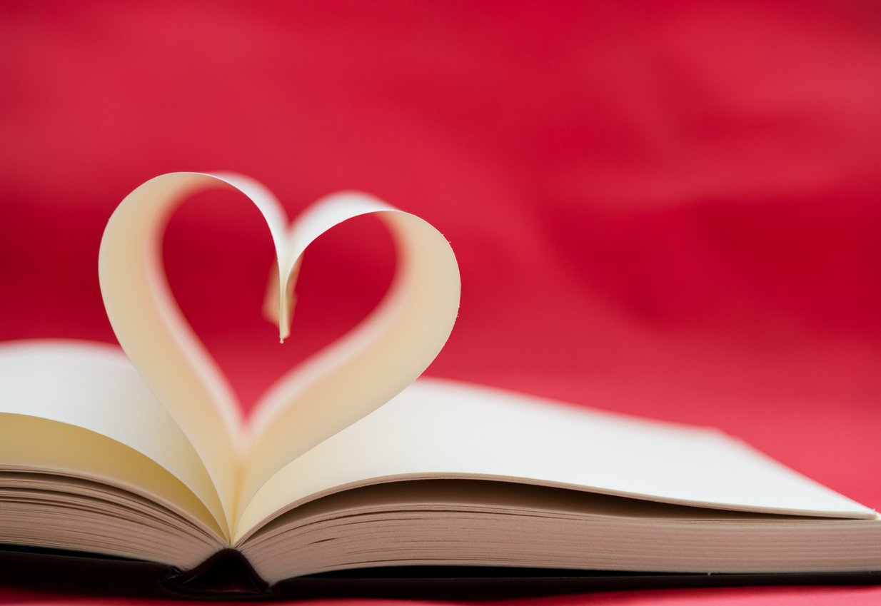 Opened book with heart shape made by the pages.